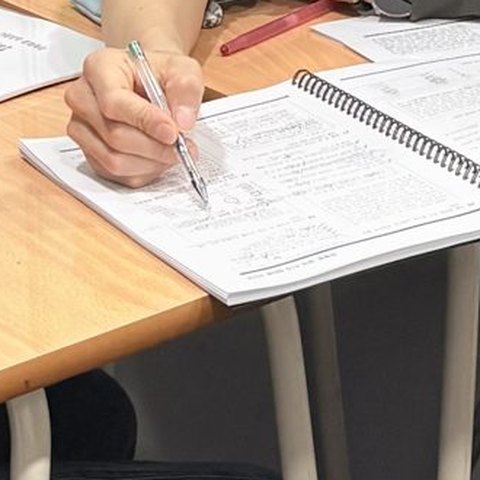 원장이 한 학생의 교재에 직접 풀이를 적어 주는 손